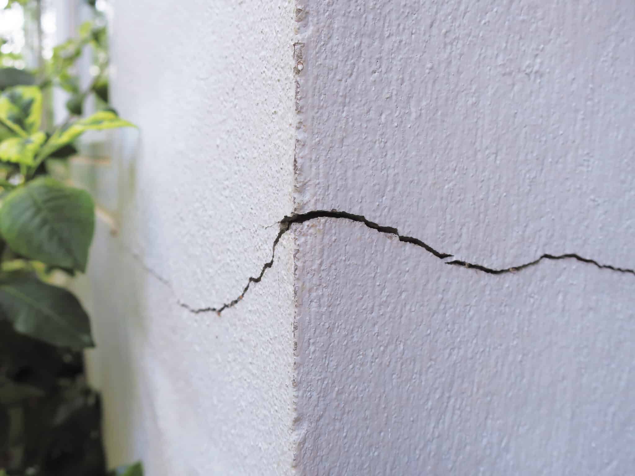 Restore Your Home's Foundation Crack Repair 1 Close-up of a wall corner with a visible crack running horizontally across the surface.