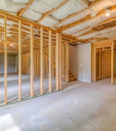 Unfinished basement with framed walls and insulated ceiling.