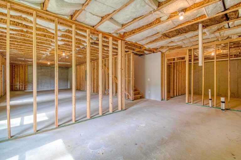 Unfinished basement with framed walls and insulated ceiling.