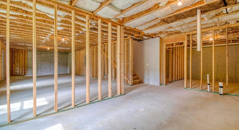 Unfinished basement with framed walls and insulated ceiling.