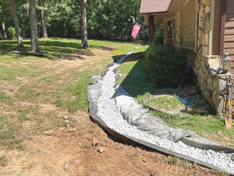 yard drainage system in a DMV home showing French drain trench and downspout extension protecting the foundation