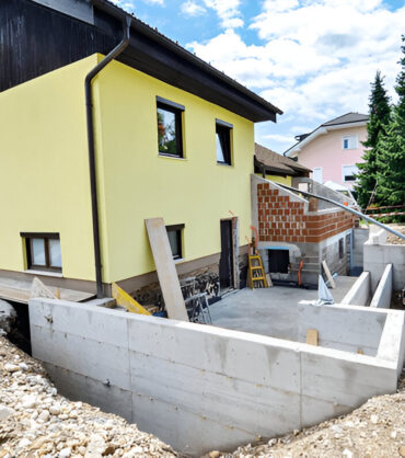 House foundation construction with concrete walls and basement waterproofing.
