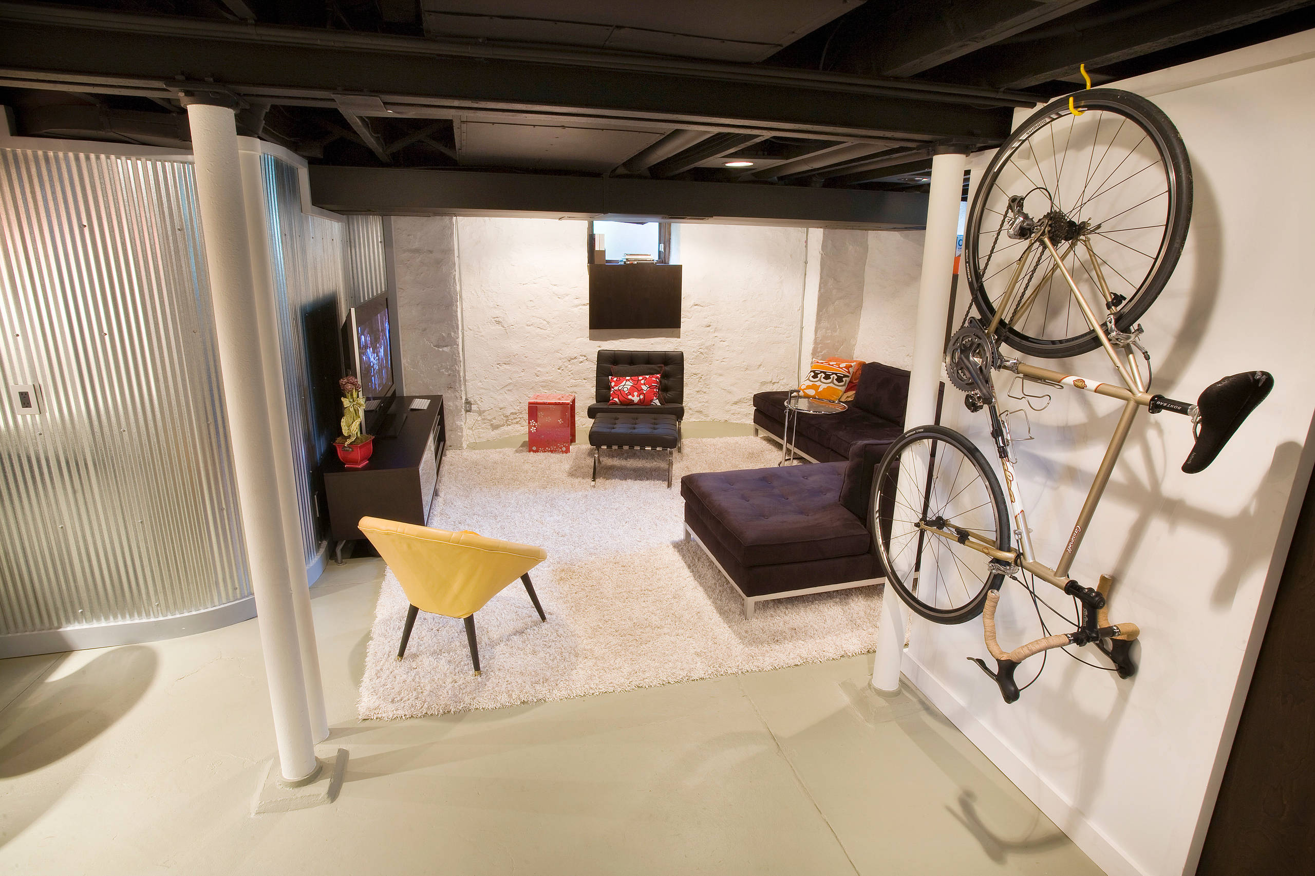 Reliable Wet Basement Specialists - Trusted Solutions 2 Modern finished basement with cozy seating area and bike storage.