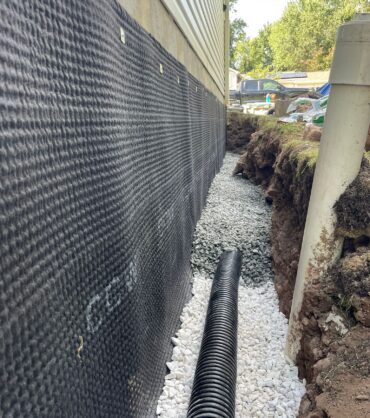 Exterior drain tile in clean stone alongside the drain board — Ashburn, VA