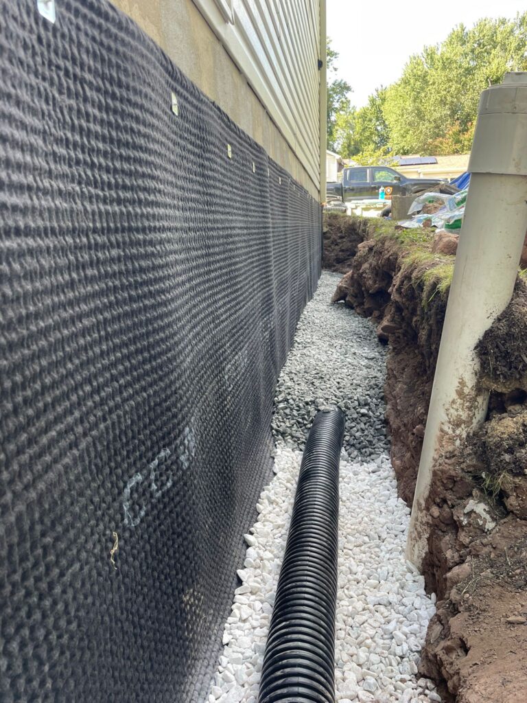 Exterior drain tile in clean stone alongside the drain board — Ashburn, VA