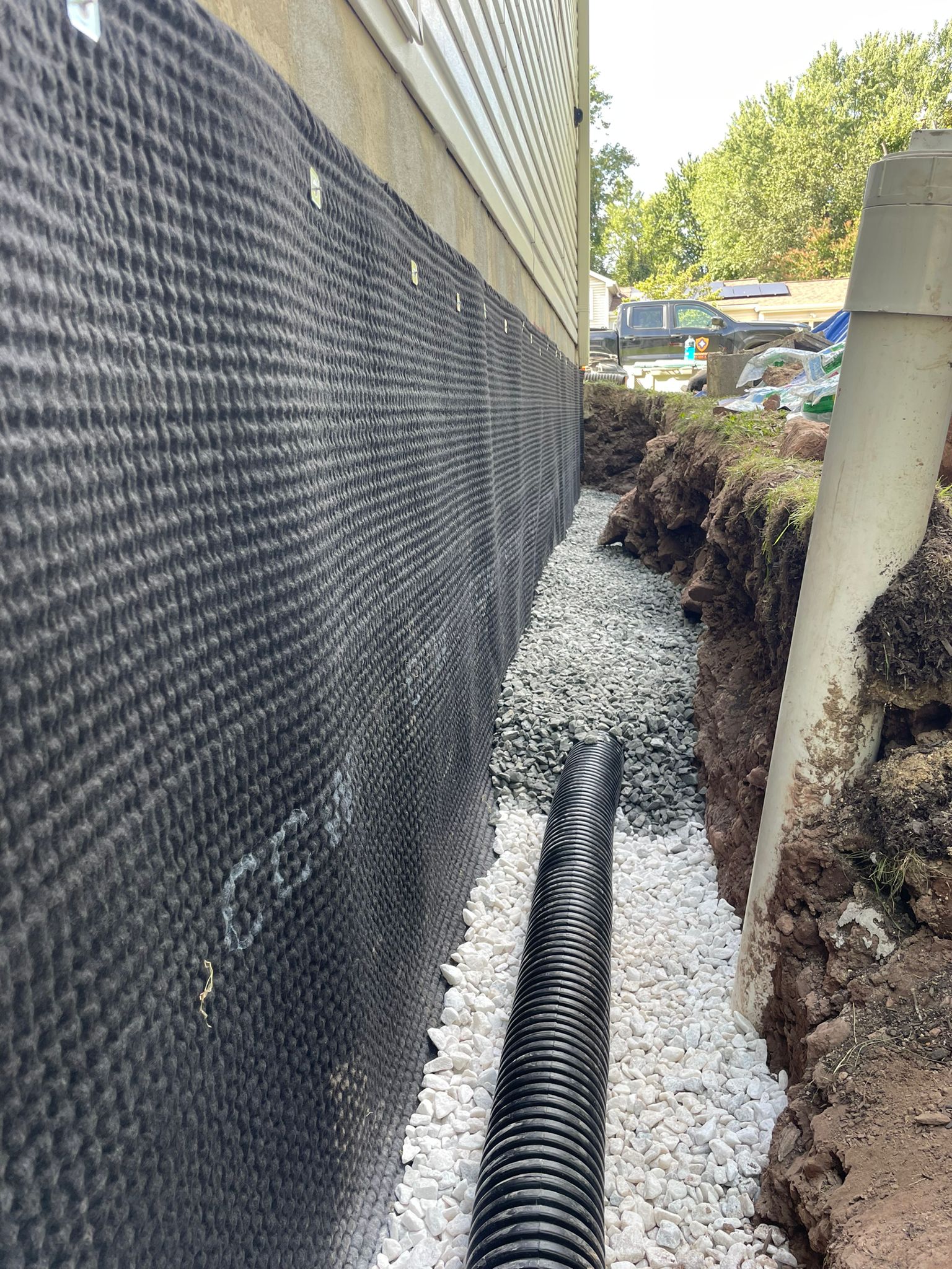Exterior drain tile in clean stone alongside the drain board — Ashburn, VA