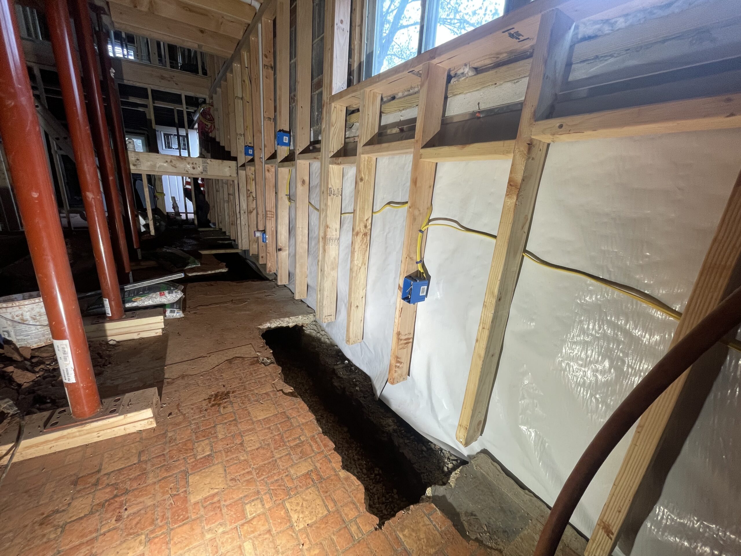 Large Manassas basement with steel support posts and the perimeter trench opened along the footing