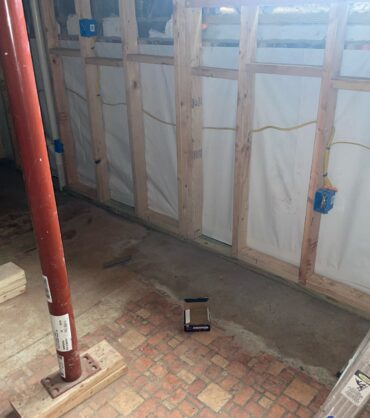 Dried, reinforced large basement with wall vapor barrier and steel support posts — Manassas, VA