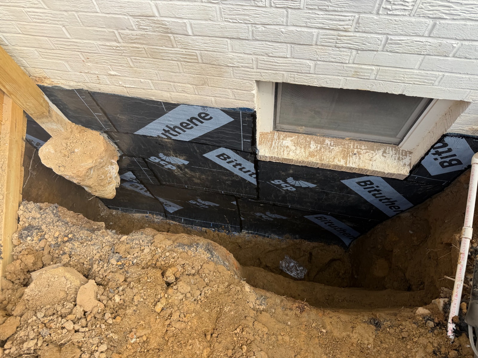 GCP Bituthene sheet membrane installed over the brick foundation wall