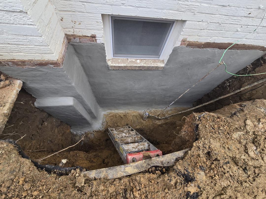 Cementitious waterproofing coat on the brick wall and window well