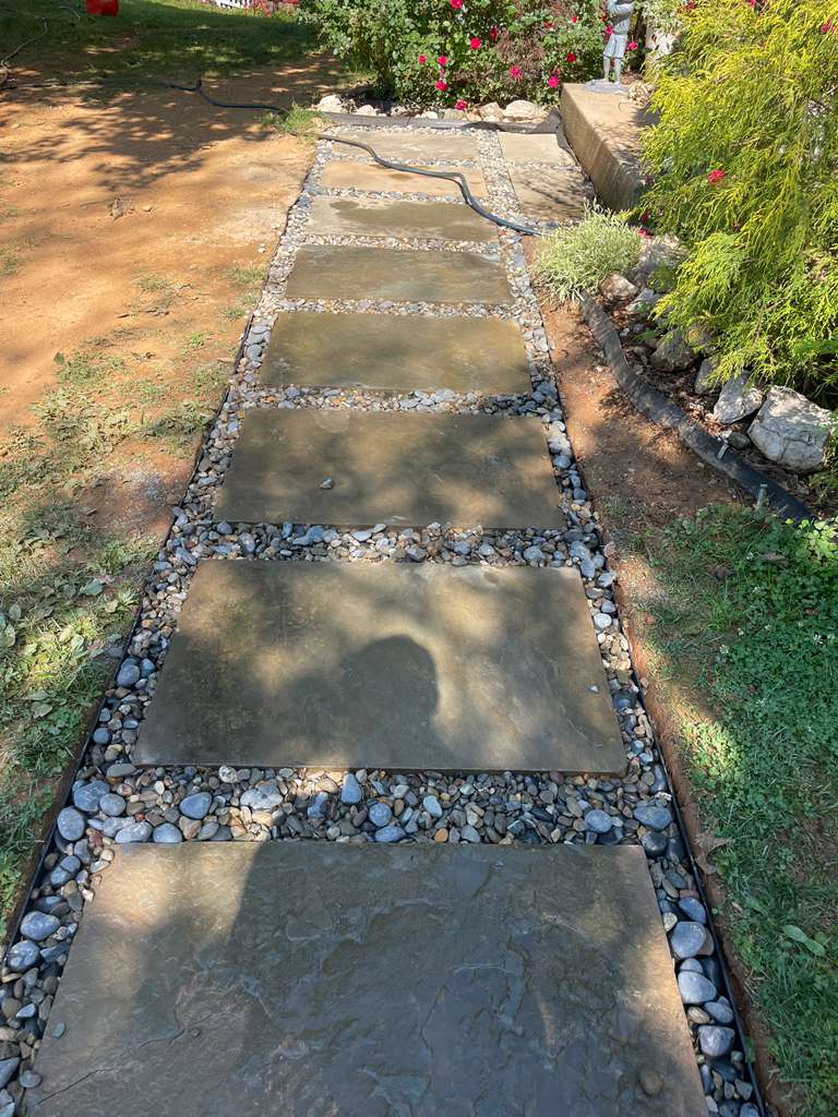Flagstone walkway reset with its river-rock border after the drain was completed — North Potomac, MD