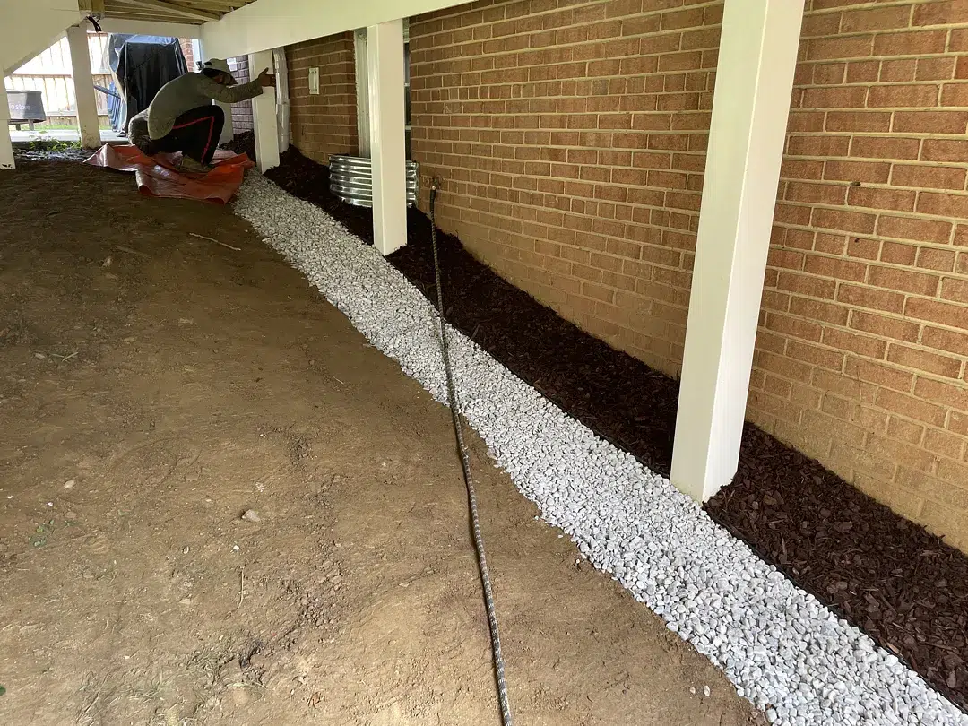 Finished gravel drainage band and graded soil beneath the preserved deck in Kensington Maryland