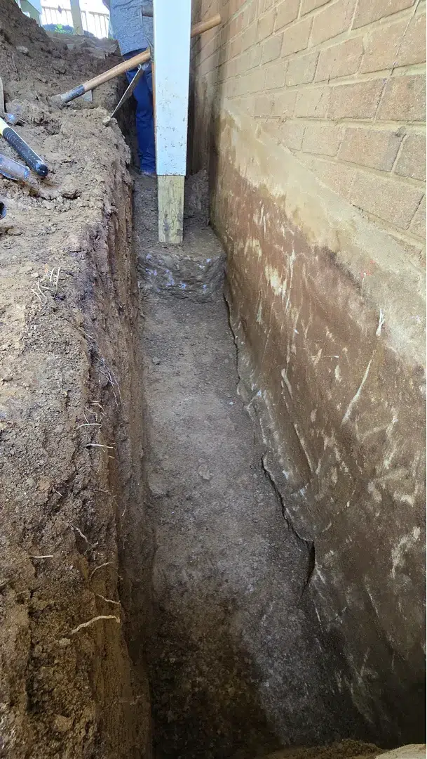 Foundation excavation beneath an existing deck at a Kensington Maryland waterproofing project