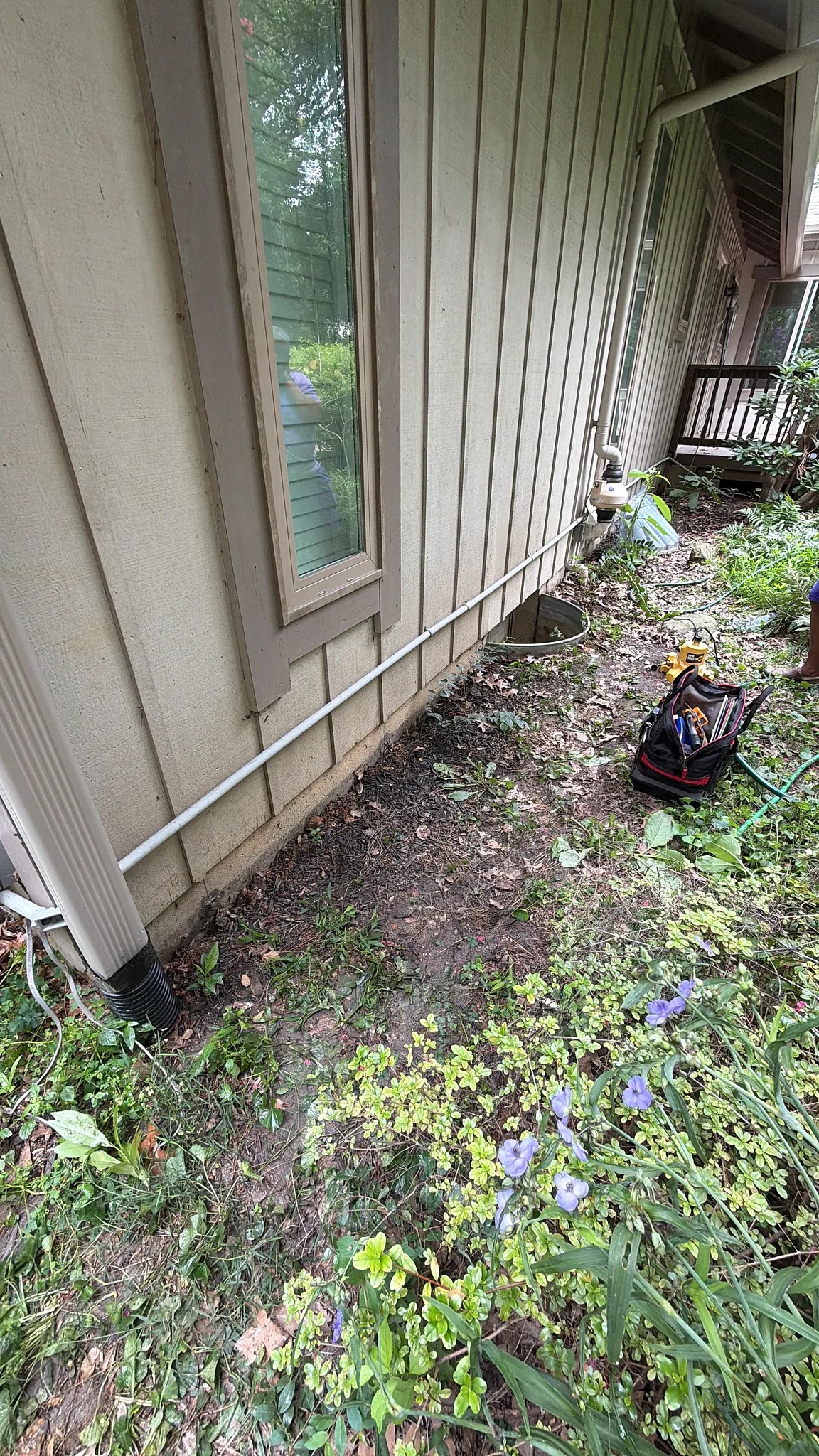 Side-yard downspout and planting bed at a Montgomery Village property before drainage work