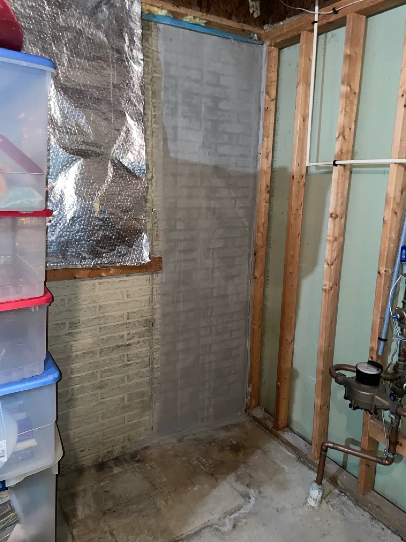 Patched wall surface after crack injection work in a Silver Spring basement