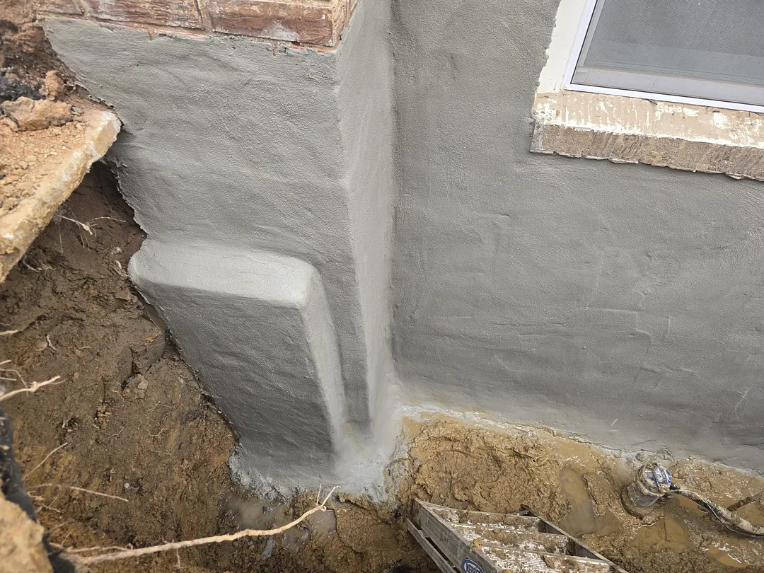 Bethesda, MD Foundation Leak: Exterior Waterproofing and Grading Tile 1 Gray cementitious waterproofing coat on the excavated Bethesda foundation wall