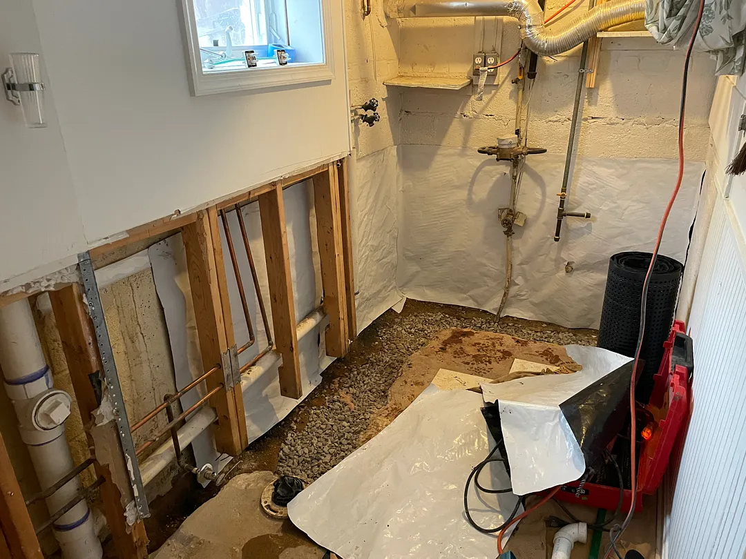 Opened lower basement wall and drainage stone along the interior perimeter in Silver Spring
