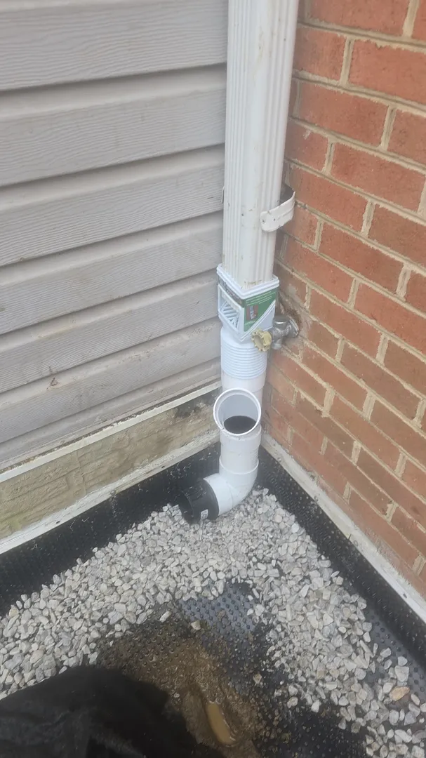 Exterior French Drain and Buried Downspout in Silver Spring, MD: A Real Front-Yard Project 2 Downspout corner and PVC fittings during installation of a buried roof-water line in Silver Spring