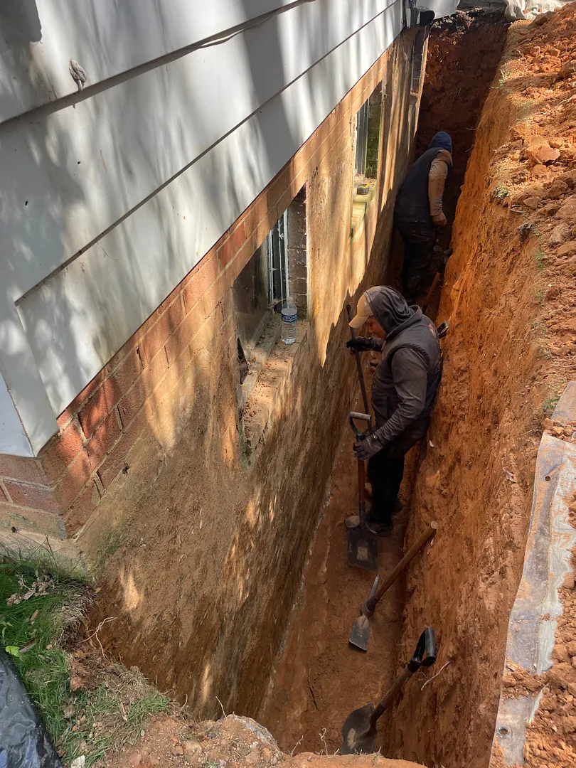 Exterior Waterproofing in Rockville, MD: Windowed Foundation Wall Case 2 Full-depth trench exposing the Rockville foundation wall beneath basement windows