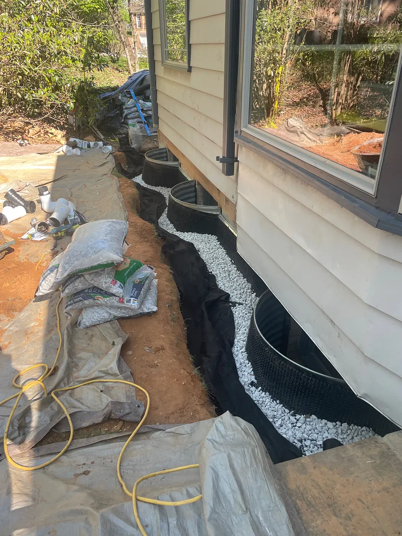 Exterior Waterproofing in Rockville, MD: Windowed Foundation Wall Case 8 Near-grade grading tile gravel band installed beside Rockville basement window wells