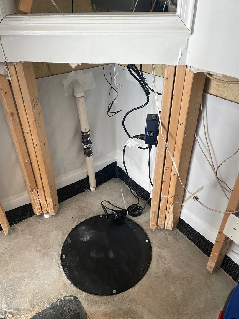 Covered sump basin beside the interior wall liner and restored concrete in Silver Spring