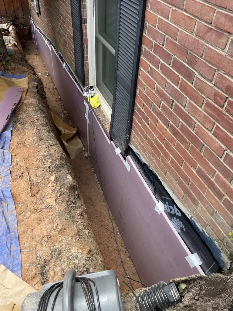 Sheet waterproofing membrane and protective insulation on an exposed Potomac, Maryland foundation wall