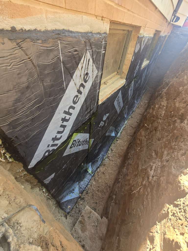 Exterior Waterproofing in Rockville, MD: Windowed Foundation Wall Case 6 Bituthene sheet waterproofing membrane installed on the excavated Rockville foundation wall beside basement windows