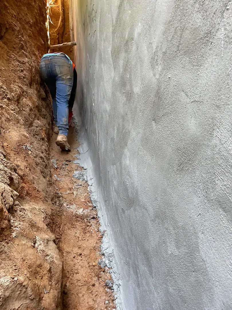 Bethesda Exterior Waterproofing Around a Basement Window Well 2 Gray cementitious waterproofing coat on an excavated Bethesda foundation wall