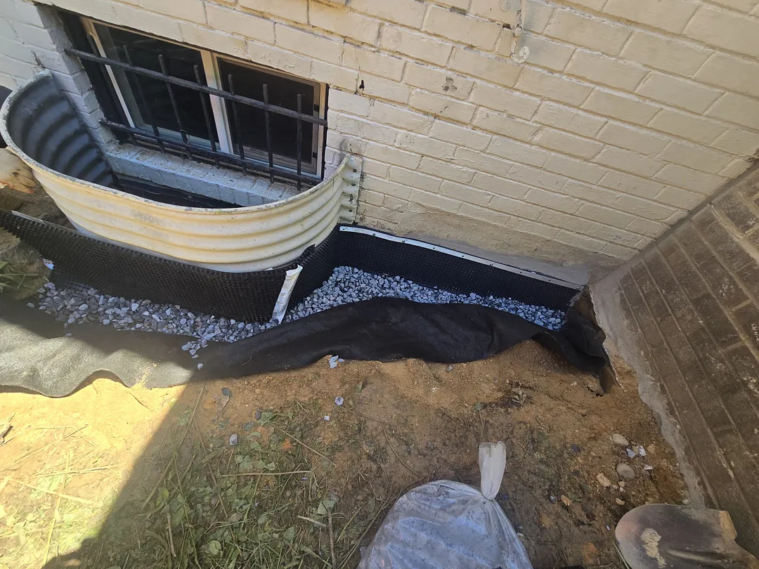 Bethesda Exterior Waterproofing Around a Basement Window Well 5 Geotextile and clean drainage stone around a Bethesda basement window well