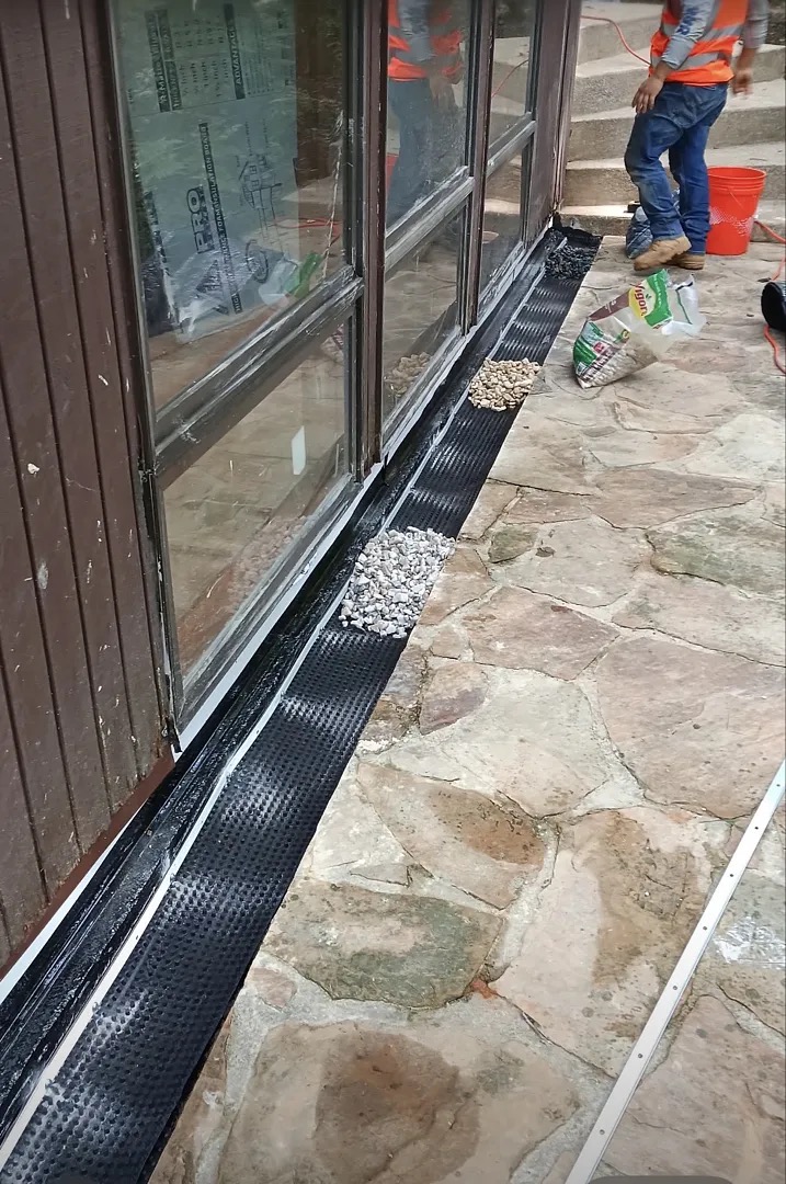 Protective edging and gravel being installed beside the patio