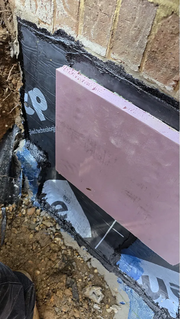 Pink XPS board protecting the exterior waterproofing membrane