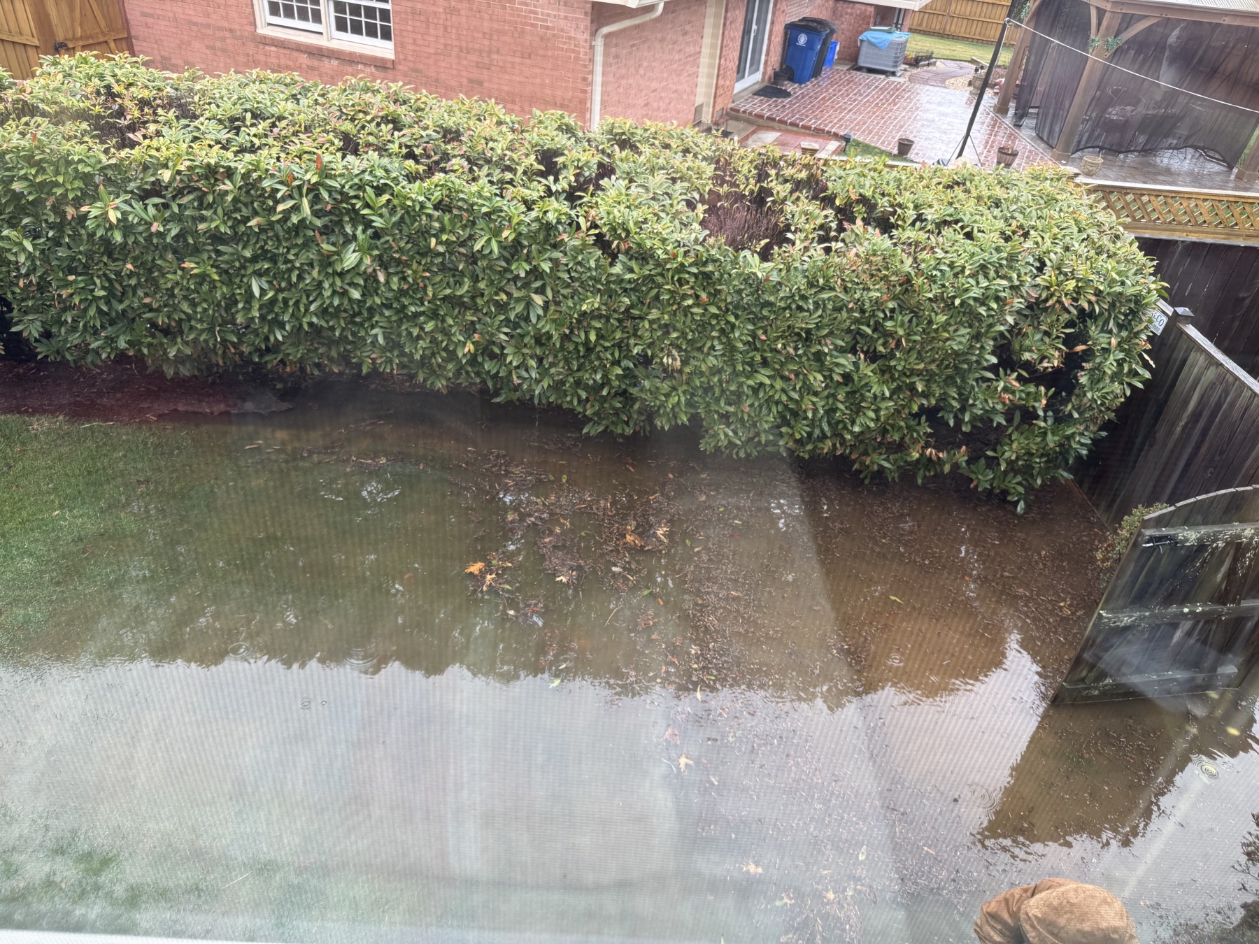 Standing floodwater across a Potomac backyard before yard drainage repairs, viewed from above