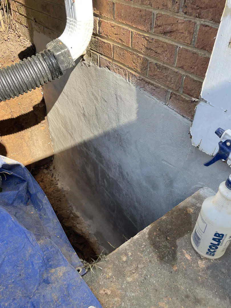 Gray cementitious first waterproofing layer on a North Potomac foundation